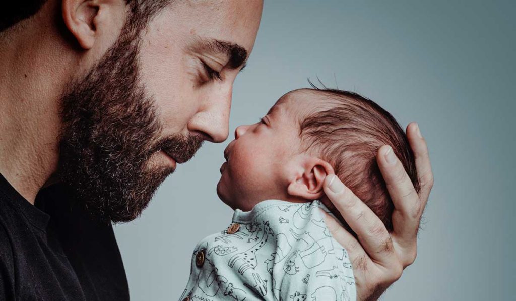 Vater hält sein Neugeborenes liebevoll nah am Gesicht