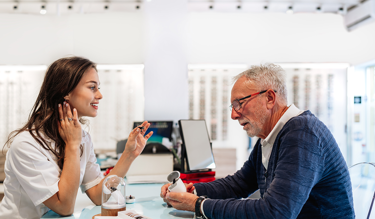Hörakustikerin berät älteren Mann zu einem Hörgerät im Fachgeschäft