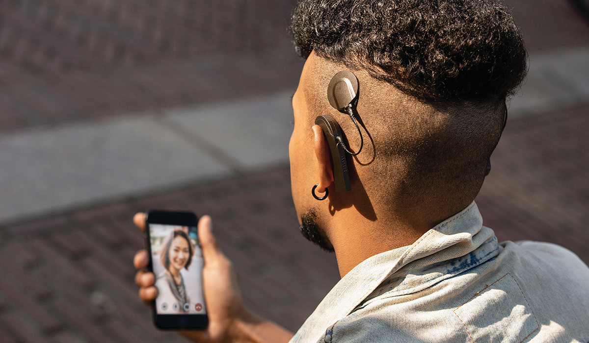 Mann mit Cochlea-Implantat telefoniert per Smartphone
